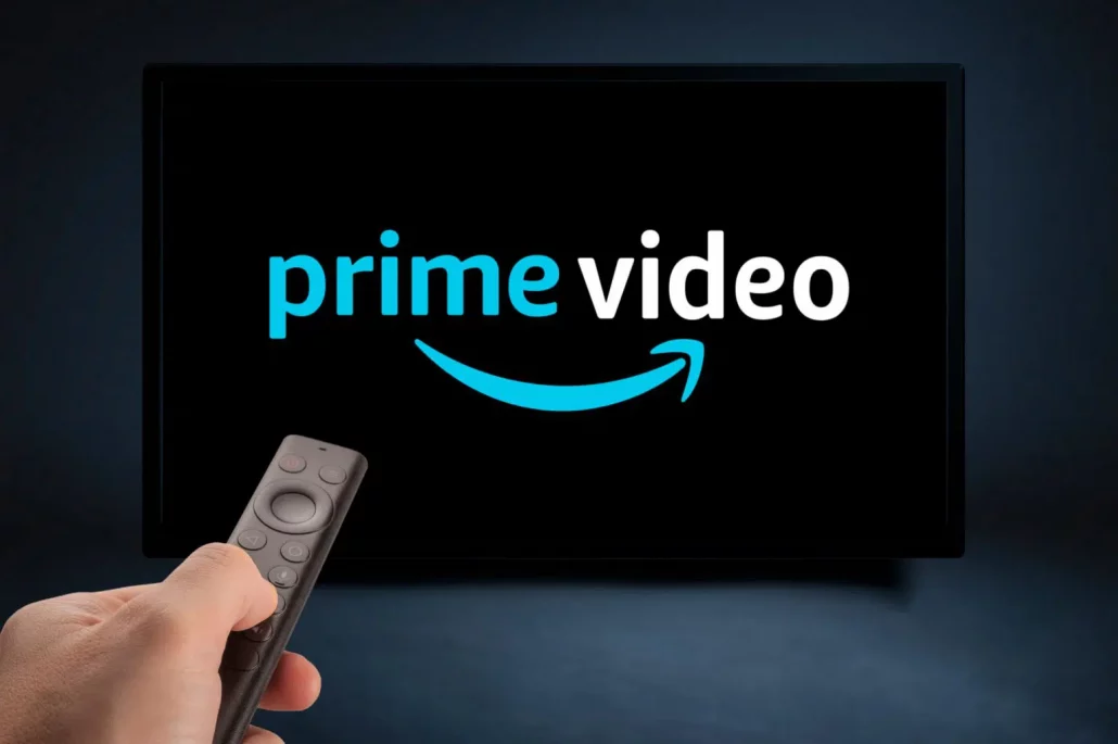 logo de Prime vidéo dans une télévision, avec une main qui tient une télécommande. 